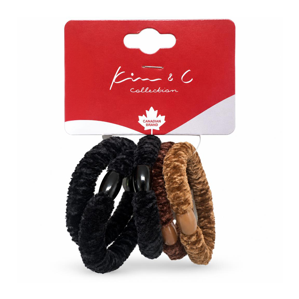 Three plush hair ties from the Kim & C Collection, featuring black, dark brown, and light brown faux fur textures with wooden beads, attached to a red cardboard hanger.