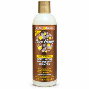A bottle of Creme Nature Pure Honey Locks in Moisturizing Dry Defense Shampoo, featuring a brown label with honeycomb graphics and a gold cap, on a white background.