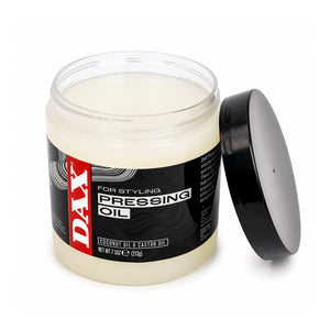 A clear plastic jar of DAX Pressing Oil with a black lid leaning against it on a white background. The jar contains a pale yellowish cream-colored balm and features a black label with a red DAX logo.